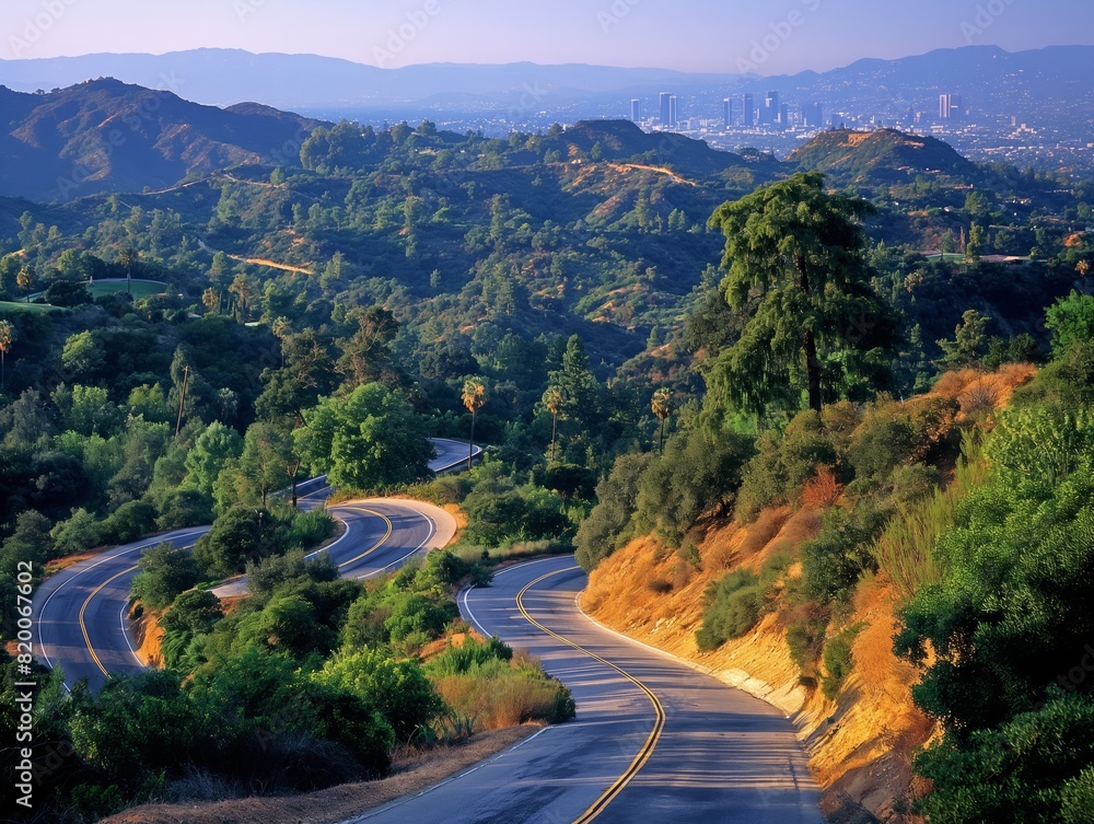 A winding road with trees and mountains in the background. The road is empty and the sky is blue A winding road with trees and mountains in the background. The road is empty and the sky is blue
