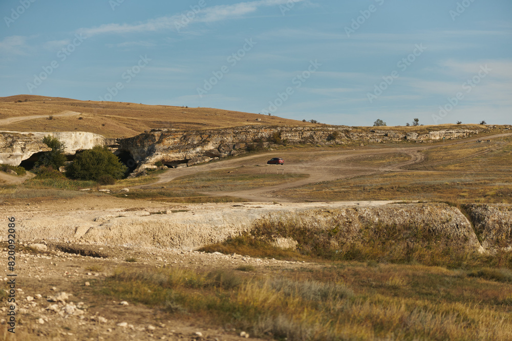 Lonely motorcycle rider exploring remote dirt road in the middle of nowhere for adventure travel enthusiasts