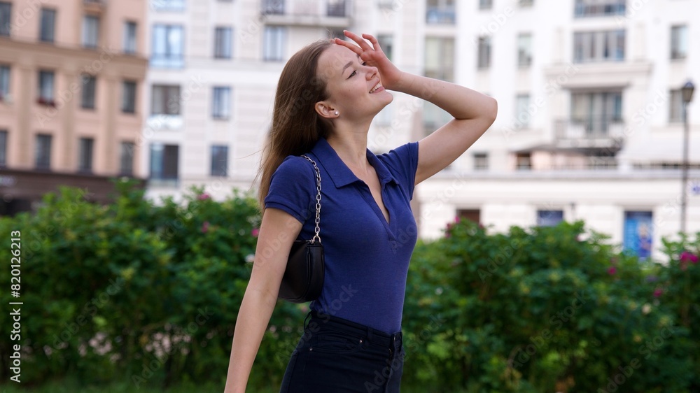 Happy young woman in the courtyard of a residential complex in the city