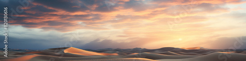 Sand dunes under sunset or sunrise glowing sky with clouds, dramatic desert landscape