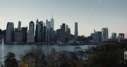Financial district in Manhattan across the East River in the morning. Panorama view from the Brooklyn Bridge Park.