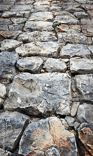 Close-up of ancient cobblestone pavement with weathered stones. Texture background for design and print