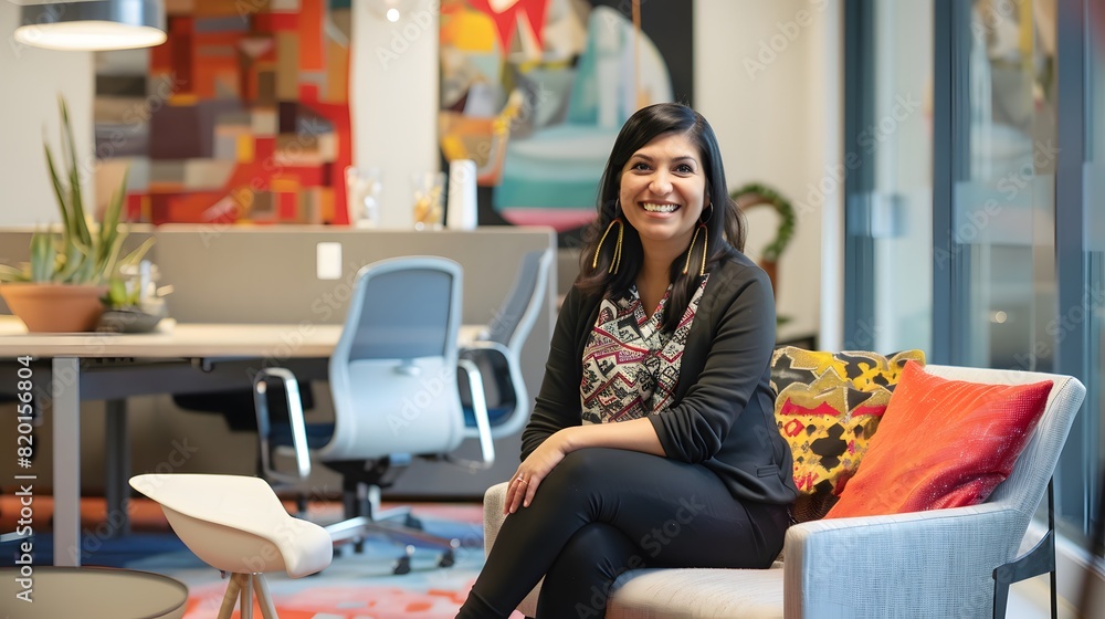 Smiling woman seated in a modern office lounge with colorful decor, exuding warmth and professionalism. Smiling woman seated in a modern office lounge with colorful decor, exuding warmth and professionalism.