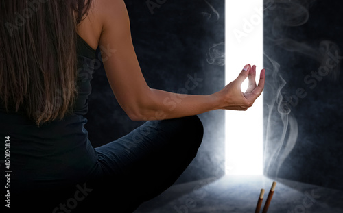 Woman meditating with incense and a passageway that opens photo