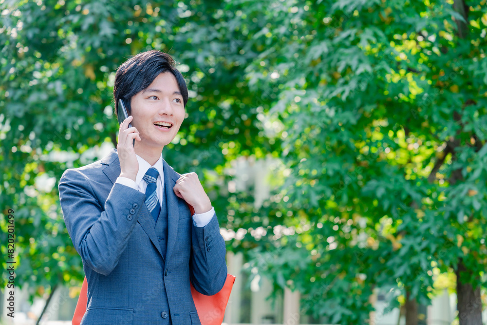 スマホで通話をする若いビジネスマン スマホで通話をする若いビジネスマン