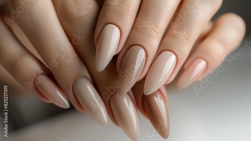Natural nude manicure on long almond-shaped nails. Studio close-up photography. Design for poster, wallpaper, banner photo