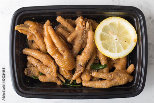 Chinese take out food chicken claw with lemon in a container