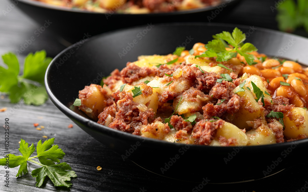 Corned beef hash with potatoes and beans in tomato sauce. Corned beef hash with potatoes and beans in tomato sauce.