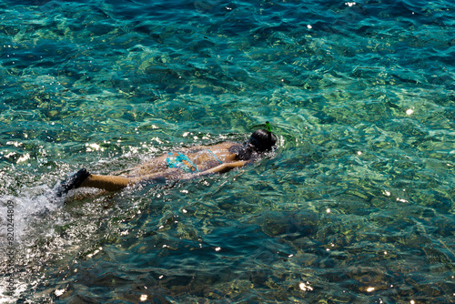 Young woman snorkeling in transparent shallow sea. Young woman snorkeling in the crystal clear waters of the Mediterranean Sea.