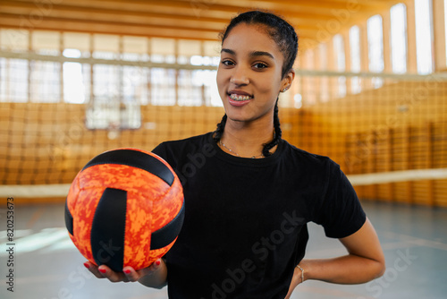 Portrait of a diverse african young female playing volleyball in a sports hall photo