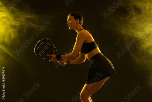 Padel tennis player with racket on tournament. Girl athlete with paddle racket on court. Sport concept. Download a high quality photo for design of a sports app or tour events.
