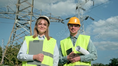 Power engineers posing for camera during inspection of electricity pylons