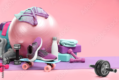 Many different sports equipment on pink background, space for text photo