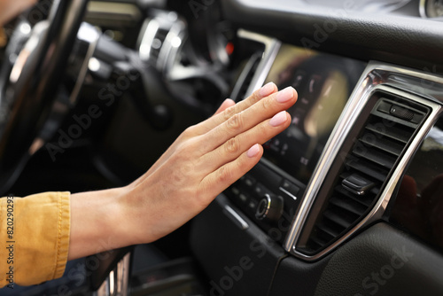 Woman checking air conditioner in her car, closeup