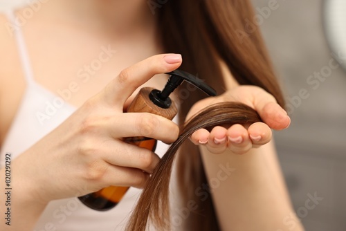 Woman applying oil hair mask indoors  closeup