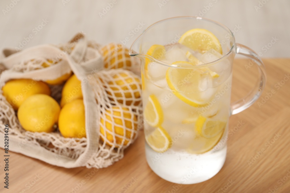 Freshly made lemonade in jug on wooden table indoors Freshly made lemonade in jug on wooden table indoors