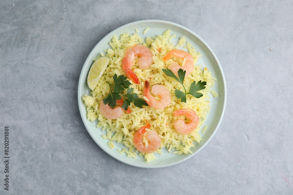 Delicious risotto with shrimps, lime and parsley on light grey table, top view Delicious risotto with shrimps, lime and parsley on light grey table, top view
