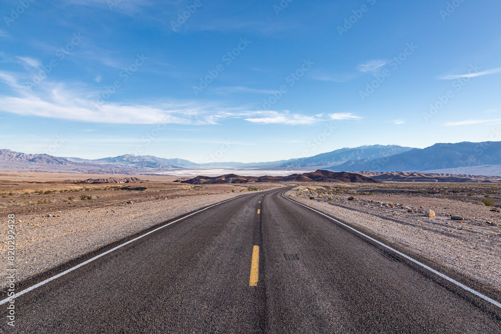 A view along a road leading into Death Valley, with the salt flats in the distance