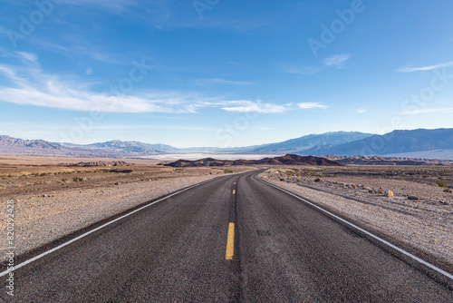 A view along a road leading into Death Valley, with the salt flats in the distance