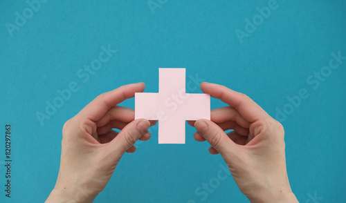 Hospital healthcare concept with hand picking up a blue cross