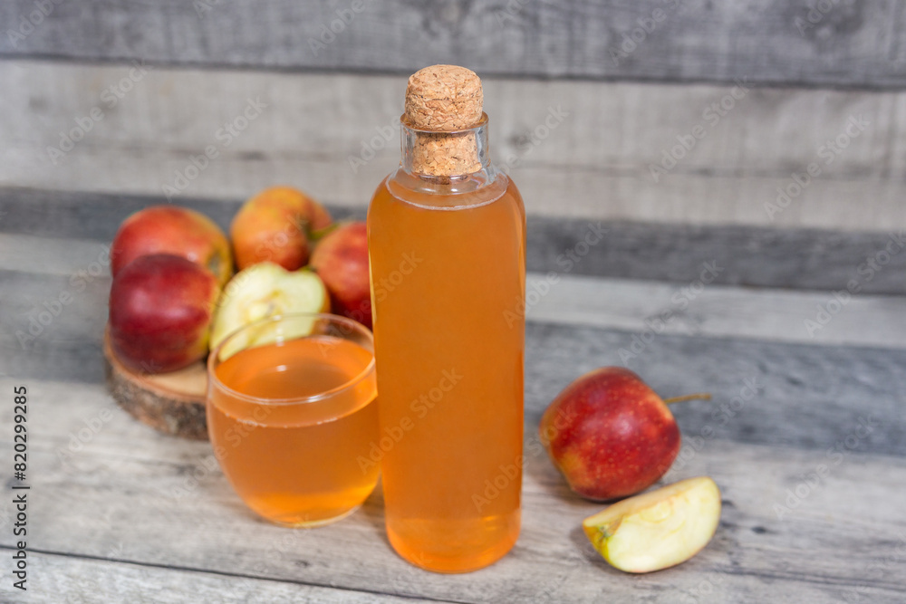 Apple vinegar. Bottle of homemade apple organic vinegar, wine or cider on dark wooden background. Healthy organic food. With copy space. Apple vinegar. Bottle of homemade apple organic vinegar, wine or cider on dark wooden background. Healthy organic food. With copy space.