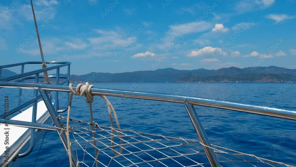 Floating hobby with lonely fishing yacht. A view of floating sunny yacht board in the blue water against tropical coastline during summer time. Floating hobby with lonely fishing yacht. A view of floating sunny yacht board in the blue water against tropical coastline during summer time.