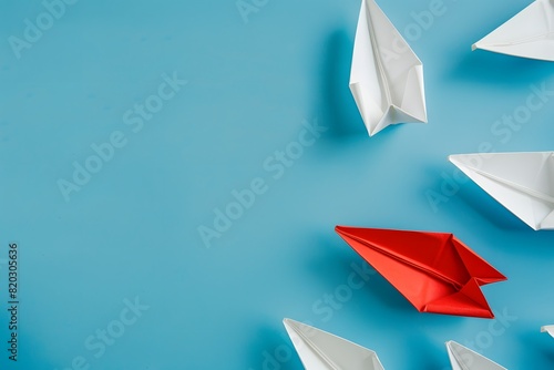 Red Paper Boat Leading White Boats on Blue Background photo