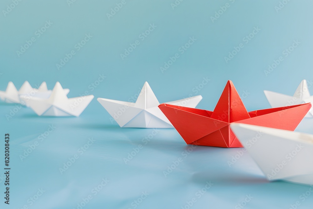 Red Paper Boat Leading Among White Boats on Blue Background Red Paper Boat Leading Among White Boats on Blue Background