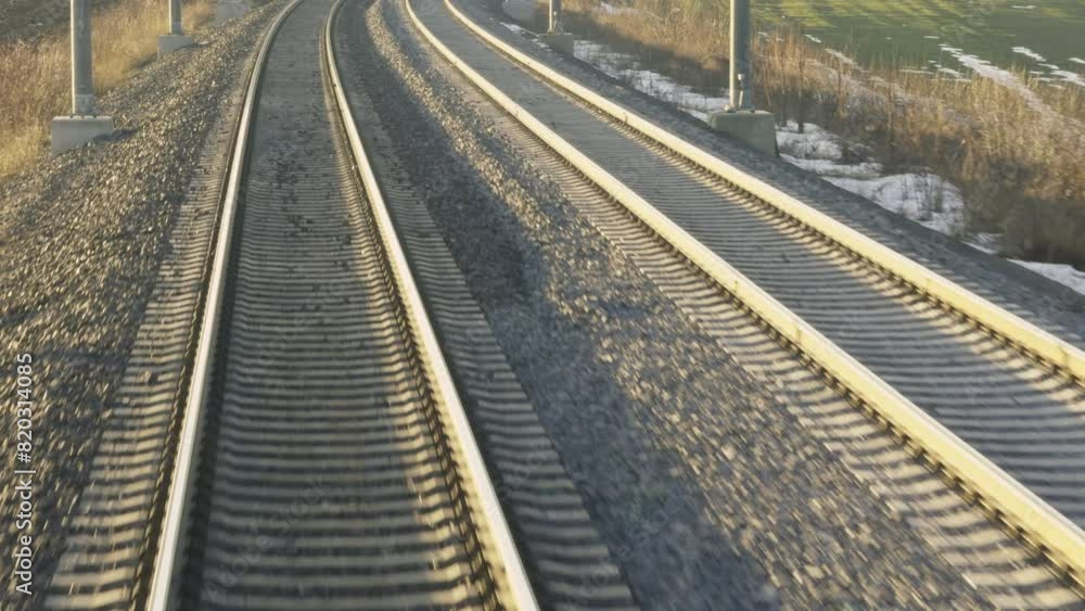 Railroad lines on gravel hill at twilight in rural site. Tranquil journey along railway view from last car. Train vehicle riding across rural area Railroad lines on gravel hill at twilight in rural site. Tranquil journey along railway view from last car. Train vehicle riding across rural area