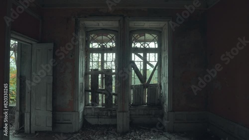 Ventanas tapiadas en una habitación de una casa abandonada con fondo de naturaleza en un día nublado photo