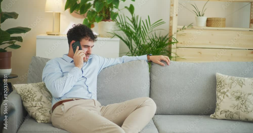 Happy Man Talks on Phone Sitting on Sofa Happy Man Talks on Phone Sitting on Sofa