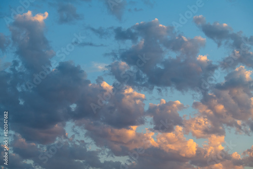 Photo of many voluminous clouds illuminated by the sun at sunset