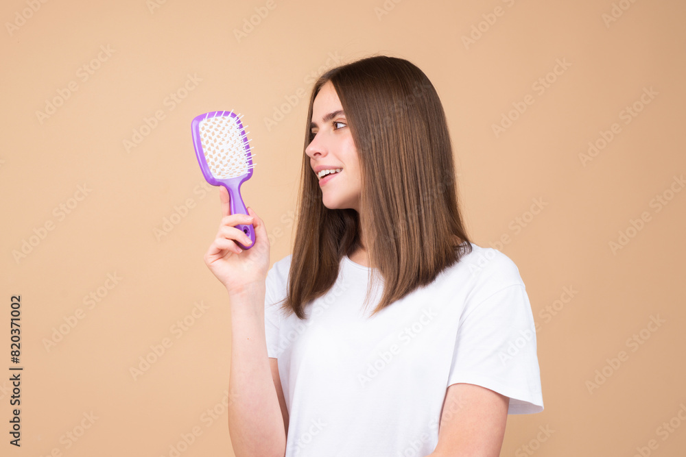 Portrait of beautiful young woman combing her hair, smiling. Female brushing healthy hair with comb. Cares about a healthy and clean hair. Beauty salon concept. Portrait of beautiful young woman combing her hair, smiling. Female brushing healthy hair with comb. Cares about a healthy and clean hair. Beauty salon concept.