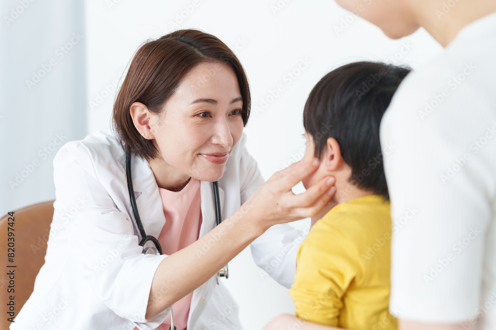 Fototapeta premium 病院で子供の診察をする女性医師