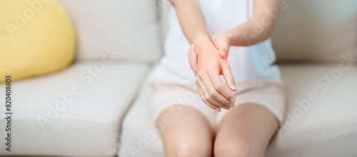 Woman having wrist pain at home, muscle ache due to De Quervain s tenosynovitis, ergonomic, Carpal Tunnel Syndrome or Office syndrome and Parkinson disease concept