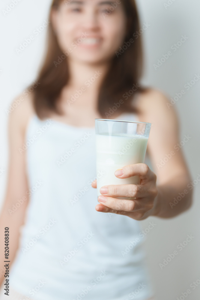 Milk drink and Daily Routine concept. Young woman Drinking milk with high calcium and nutrition at home, woman holding soy milk on glass with protein. Healthy, wellness and happy lifestyle Milk drink and Daily Routine concept. Young woman Drinking milk with high calcium and nutrition at home, woman holding soy milk on glass with protein. Healthy, wellness and happy lifestyle
