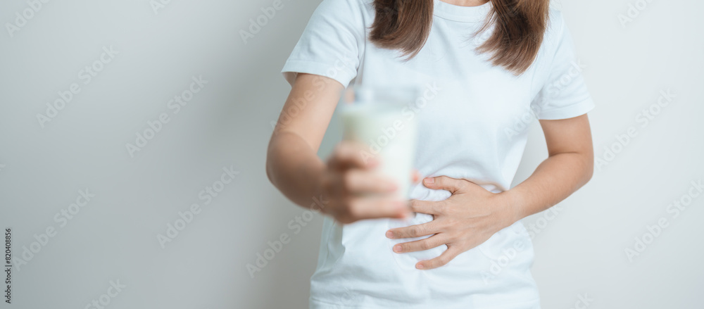 Lactose intolerance and Milk allergy concept. woman hold Milk glass and having abdominal cramps and pain when drink Cow Milk. Symptom stomach ache, Dairy intolerant, Nausea, Bloating, Gas and Diarrhea Lactose intolerance and Milk allergy concept. woman hold Milk glass and having abdominal cramps and pain when drink Cow Milk. Symptom stomach ache, Dairy intolerant, Nausea, Bloating, Gas and Diarrhea