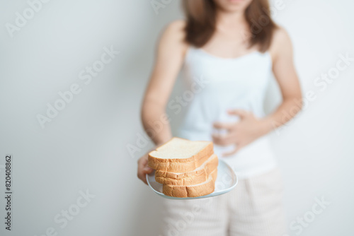 Gluten intolerance, Gluten free and celiac disease or wheat allergy concept. woman hold Bread and having abdominal pain after eat gluten. stomach ache, Nausea, Bloating, Gas, Diarrhea and Skin rash photo
