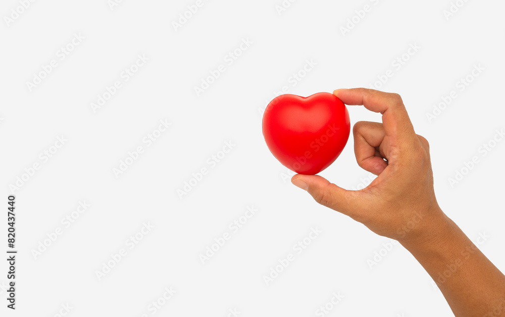 Hand holding a red heart-shaped object against a white background. Hand holding a red heart-shaped object against a white background.