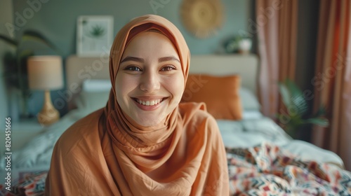 Close up view of the face of a Muslim woman wearing a hijab making a video call in the bedroom. photo