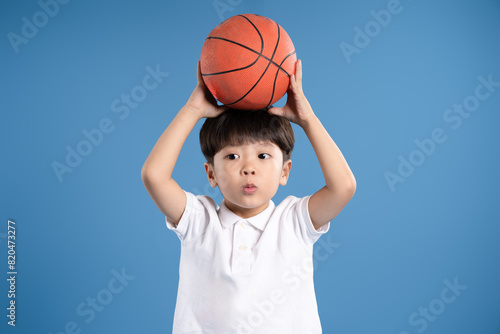 Portrait of boy in tank top playing basketball and