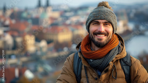 Happy male traveler wearing casual outdoor attire posing with a historical city view behind him © boxstock production