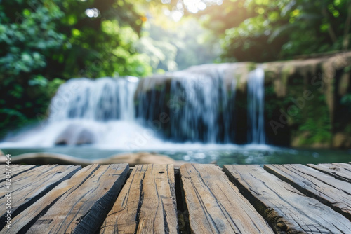A wooden desk top with blurred background of waterfall. Good for background