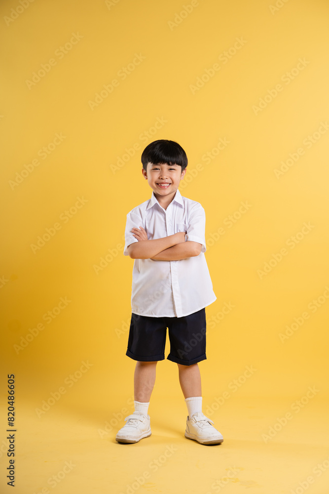 Portrait of adorable asian boy posing on yellow background Portrait of adorable asian boy posing on yellow background