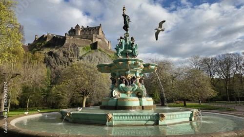 Slowmotion seagull flying around the Ross Fountain in Edinburgh on a sunny day. photo