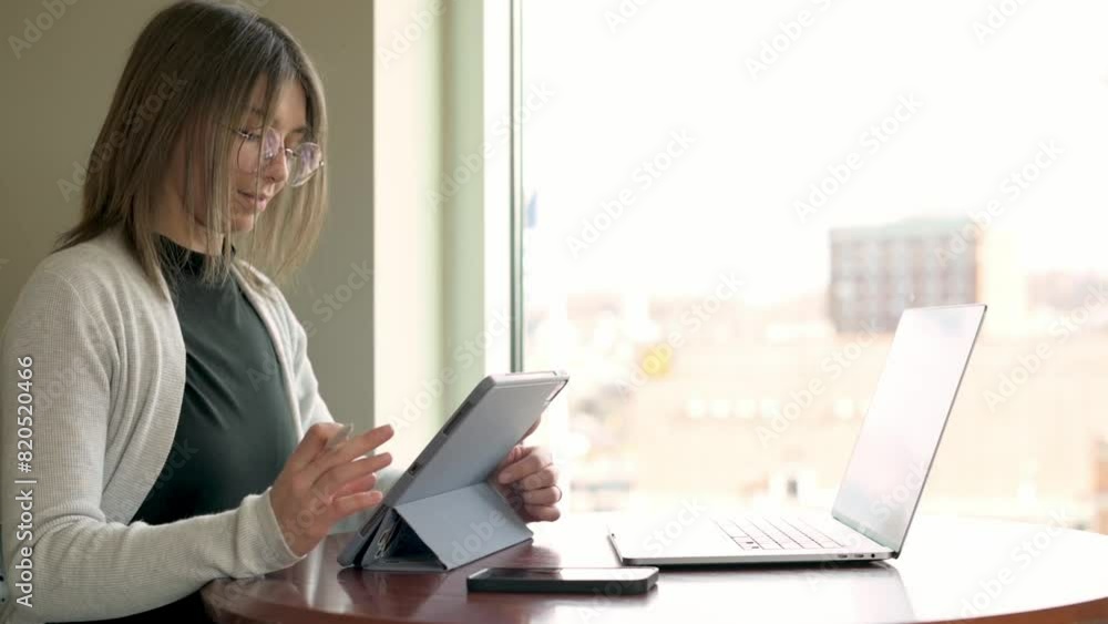 diligent student utilizes tablet to research laptop open beside her in sunlit office urban backdrop emphasizes focused academic setting blending technology and learning modern educational environment diligent student utilizes tablet to research laptop open beside her in sunlit office urban backdrop emphasizes focused academic setting blending technology and learning modern educational environment