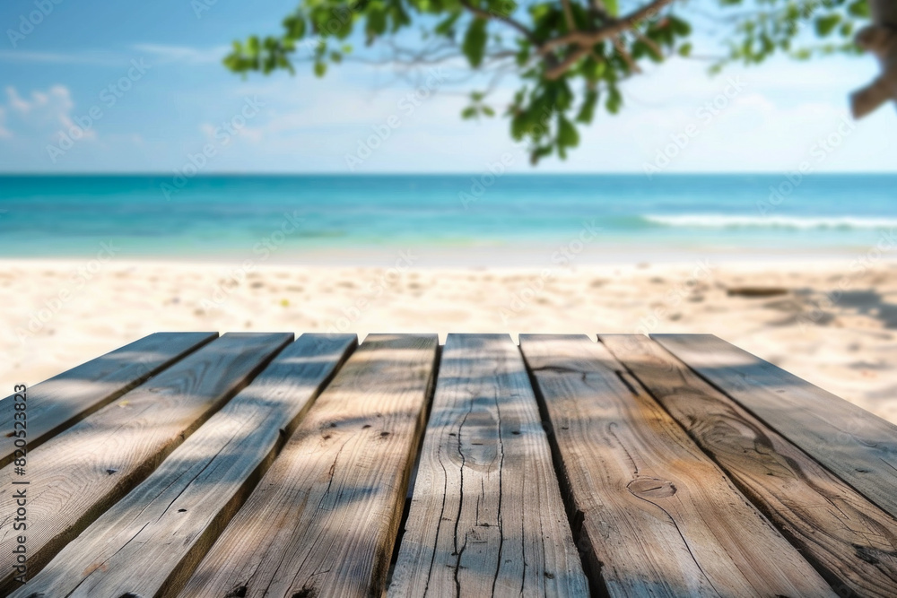 Fototapeta premium A wooden desk top with blurred background of beach. Good for background 