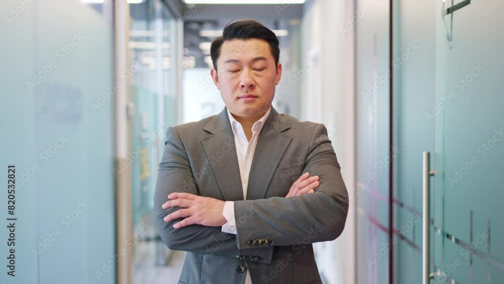 Serious male standing with arms folded and expression composed and focused emotions while meeting camera gaze. Man exuding professionalism in elegant attire in modern setting of corporate workspace. Serious male standing with arms folded and expression composed and focused emotions while meeting camera gaze. Man exuding professionalism in elegant attire in modern setting of corporate workspace.