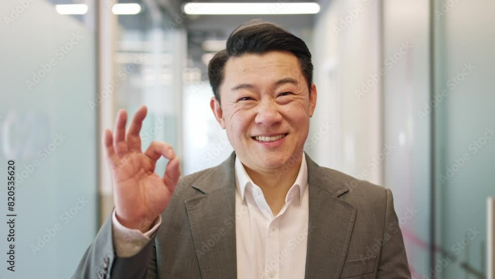 Professional young male business owner showing positive approval sing with okay hand sign in well-organized office setting. Excited man worker looking at camera with pleasant smile on face indoors. Professional young male business owner showing positive approval sing with okay hand sign in well-organized office setting. Excited man worker looking at camera with pleasant smile on face indoors.