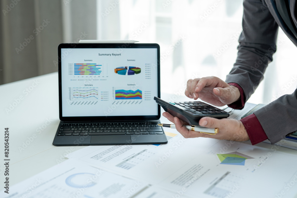 A man is looking at a laptop with a summary report on it A man is looking at a laptop with a summary report on it